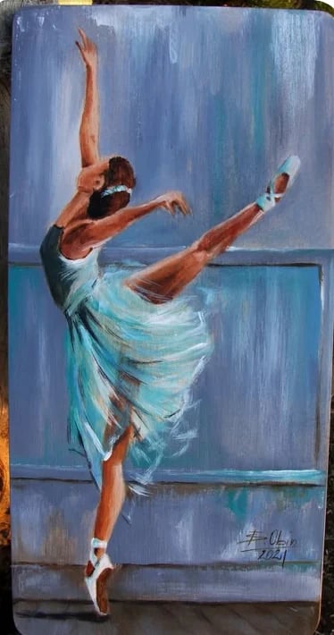 Ballet dancer in pointe shoes performing an arabesque in a flowing turquoise skirt against a blue painted background